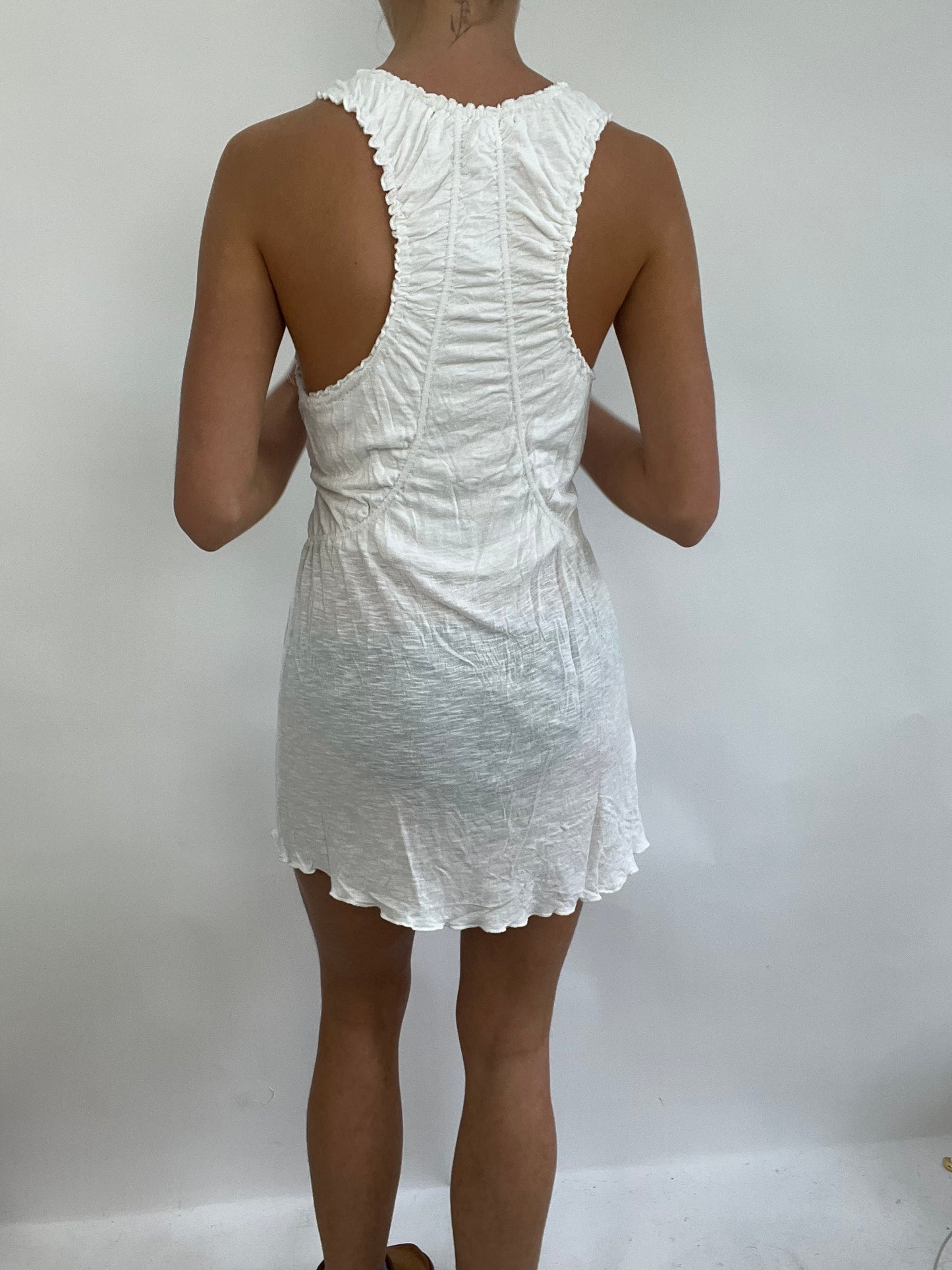 COACHELLA DROP | small white stretchy dress with v neck detail, ruching around the straps and small flower detail on the bottom