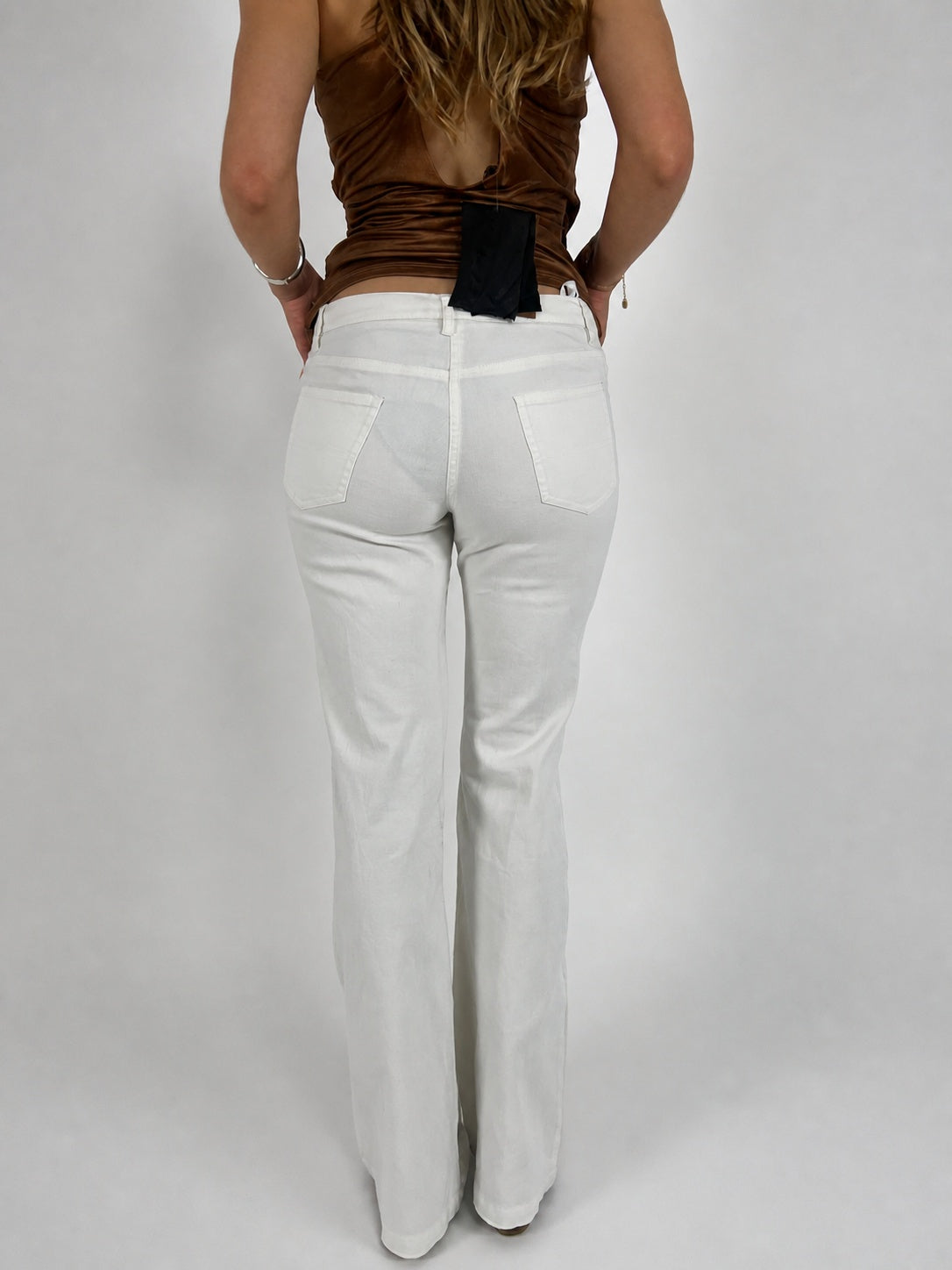 white low-rise flared trousers back view