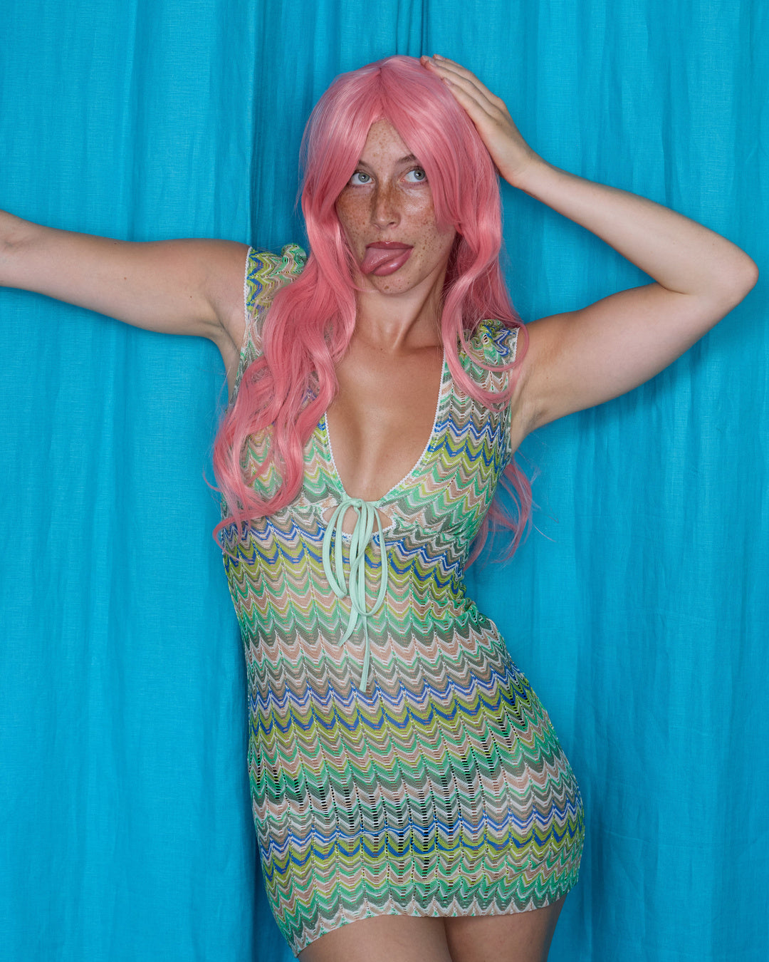 Allegra Dress in Pistachio Green – campaign pose on blue backdrop