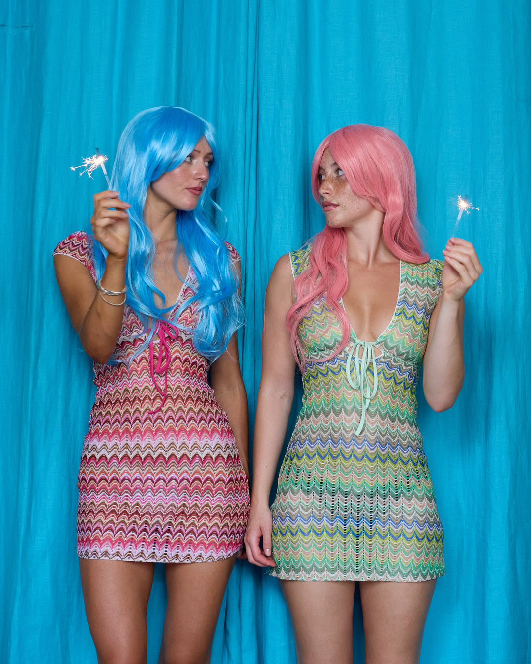 Models wearing Allegra Dresses in both colourways and holding sparklers