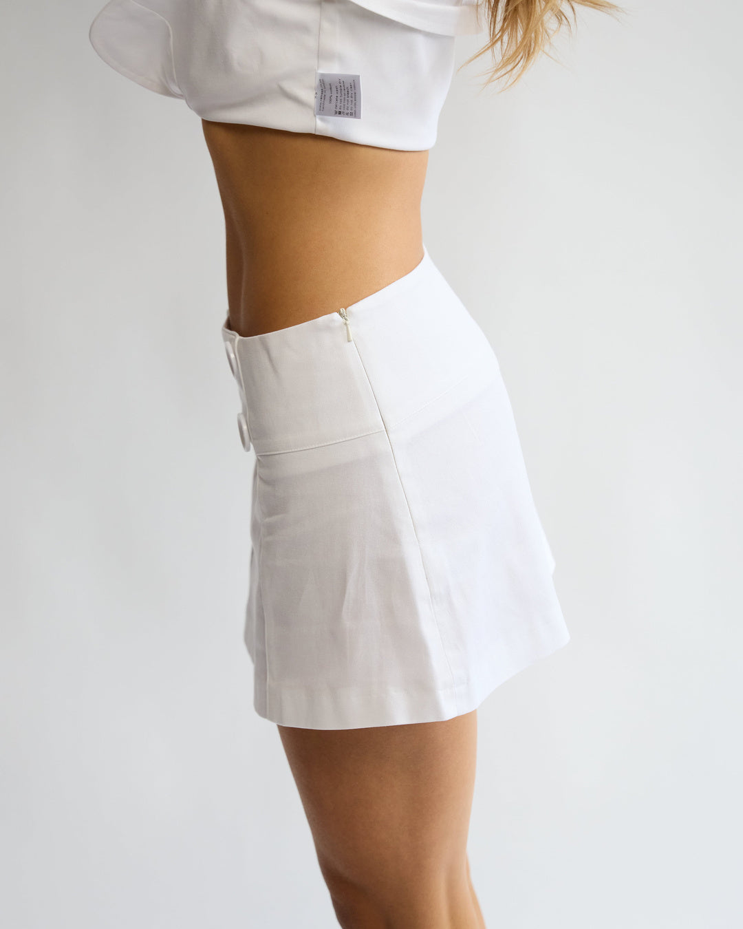 Model wearing the Penelope Pea Skirt in White – side view