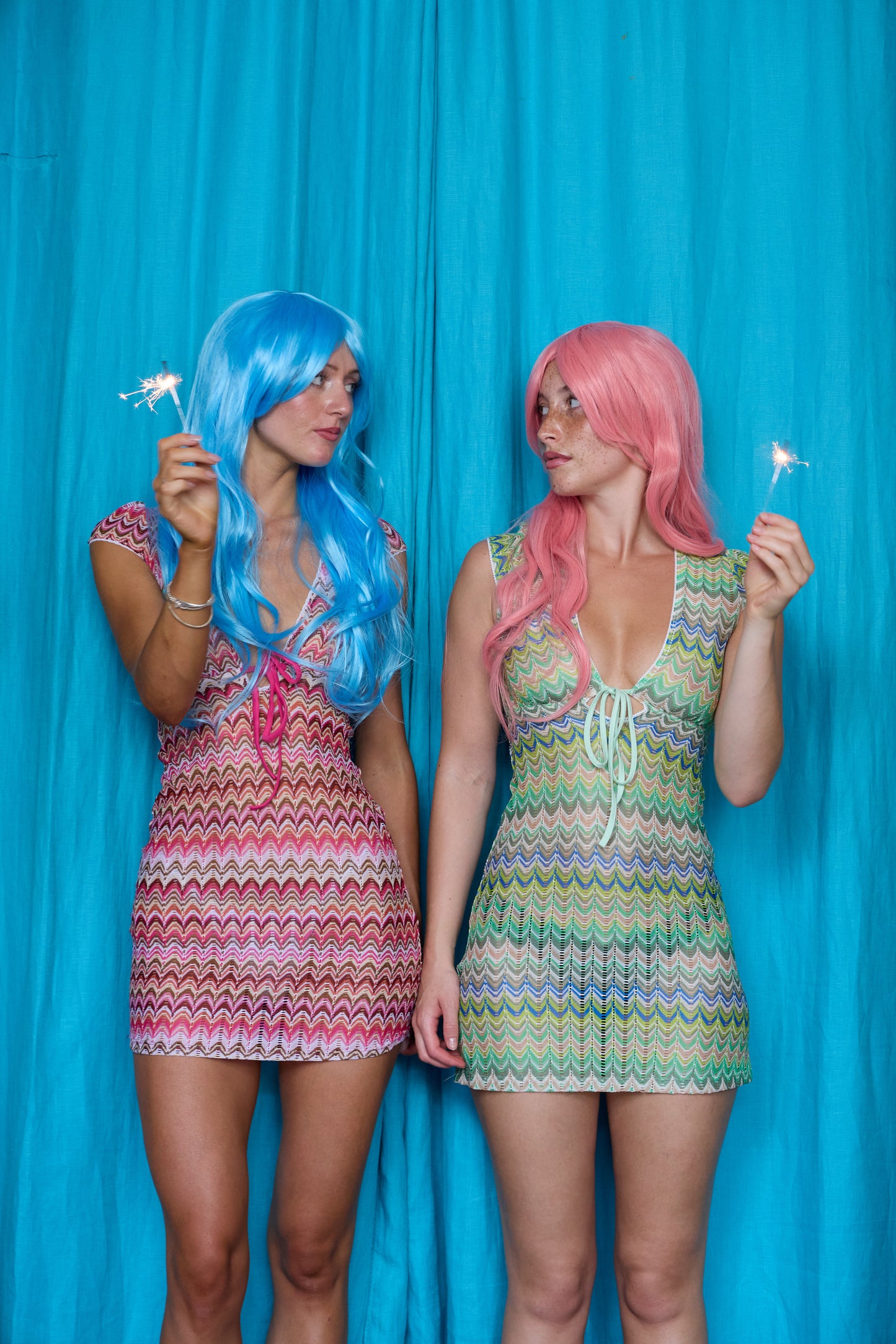 Models wearing Allegra Dresses in both colourways and holding sparklers