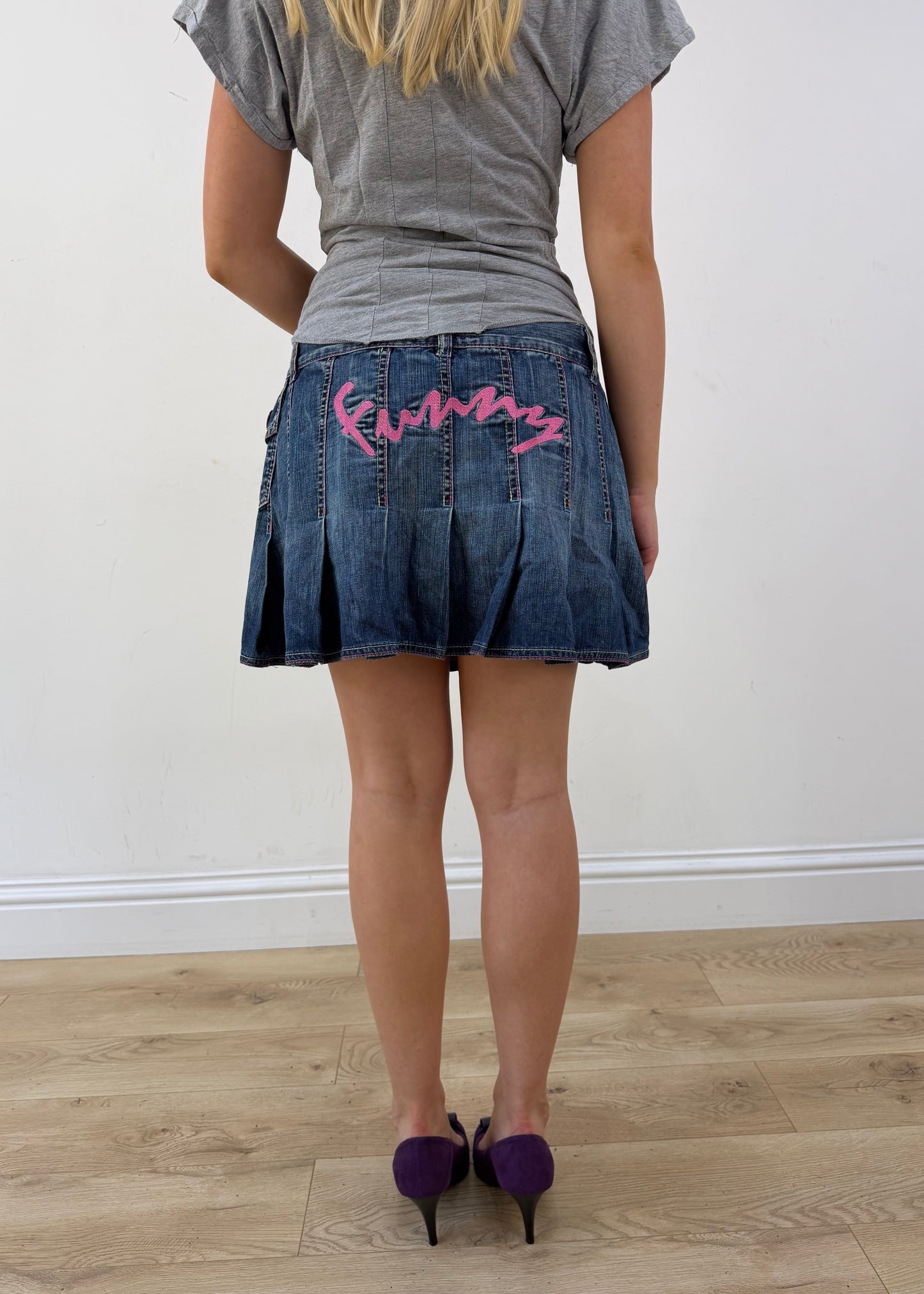 medium denim pleated mini skirt with pink spellout on the back