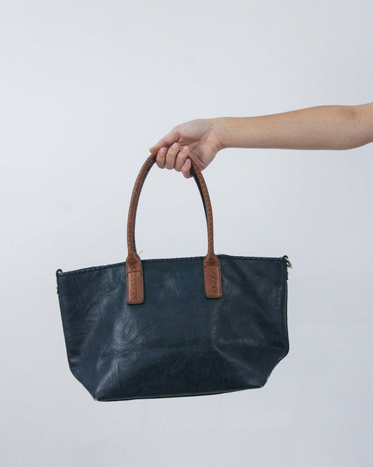 navy handbag with brown handles, front view