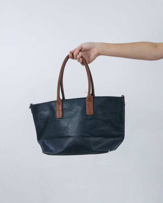 navy handbag with brown handles, back view