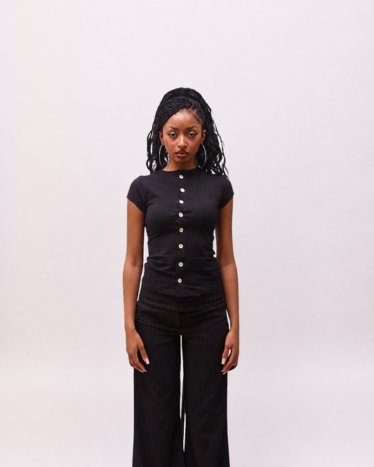 front view of the Maeva black button-front top on model