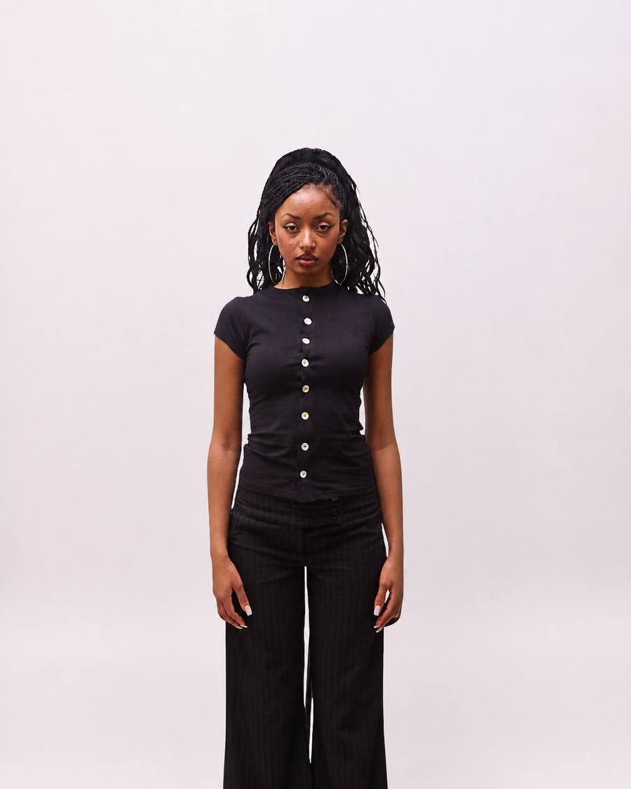 front view of the Maeva black button-front top on model
