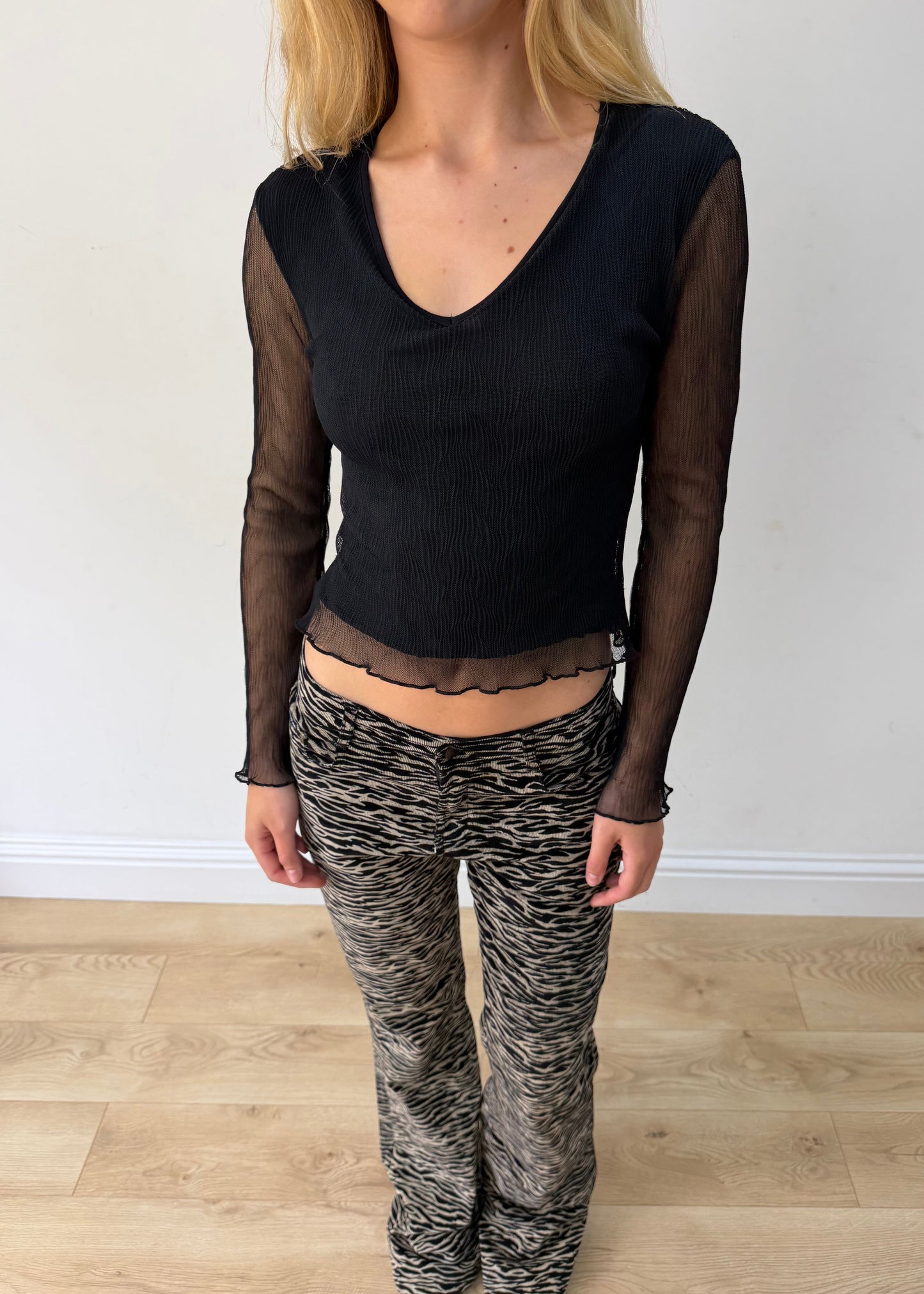 small black mesh ruffle-hem long-sleeve top — photographed on Lily