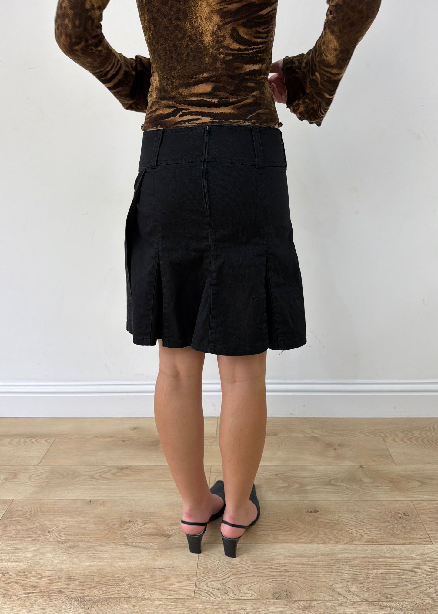 medium black pleated mini skirt — photographed on Lily