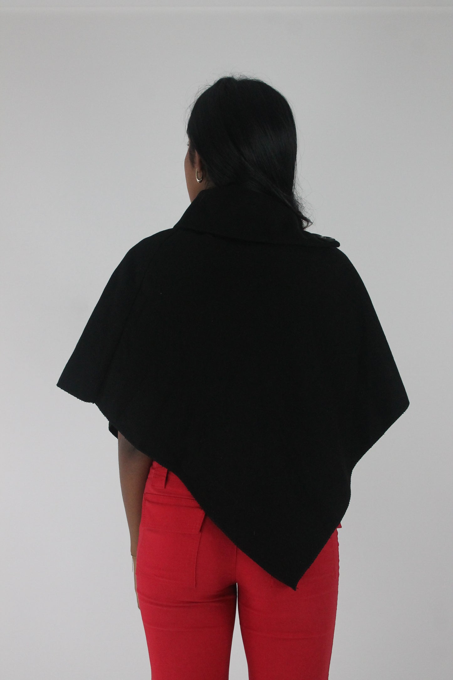 back view of black button-detail asymmetric poncho