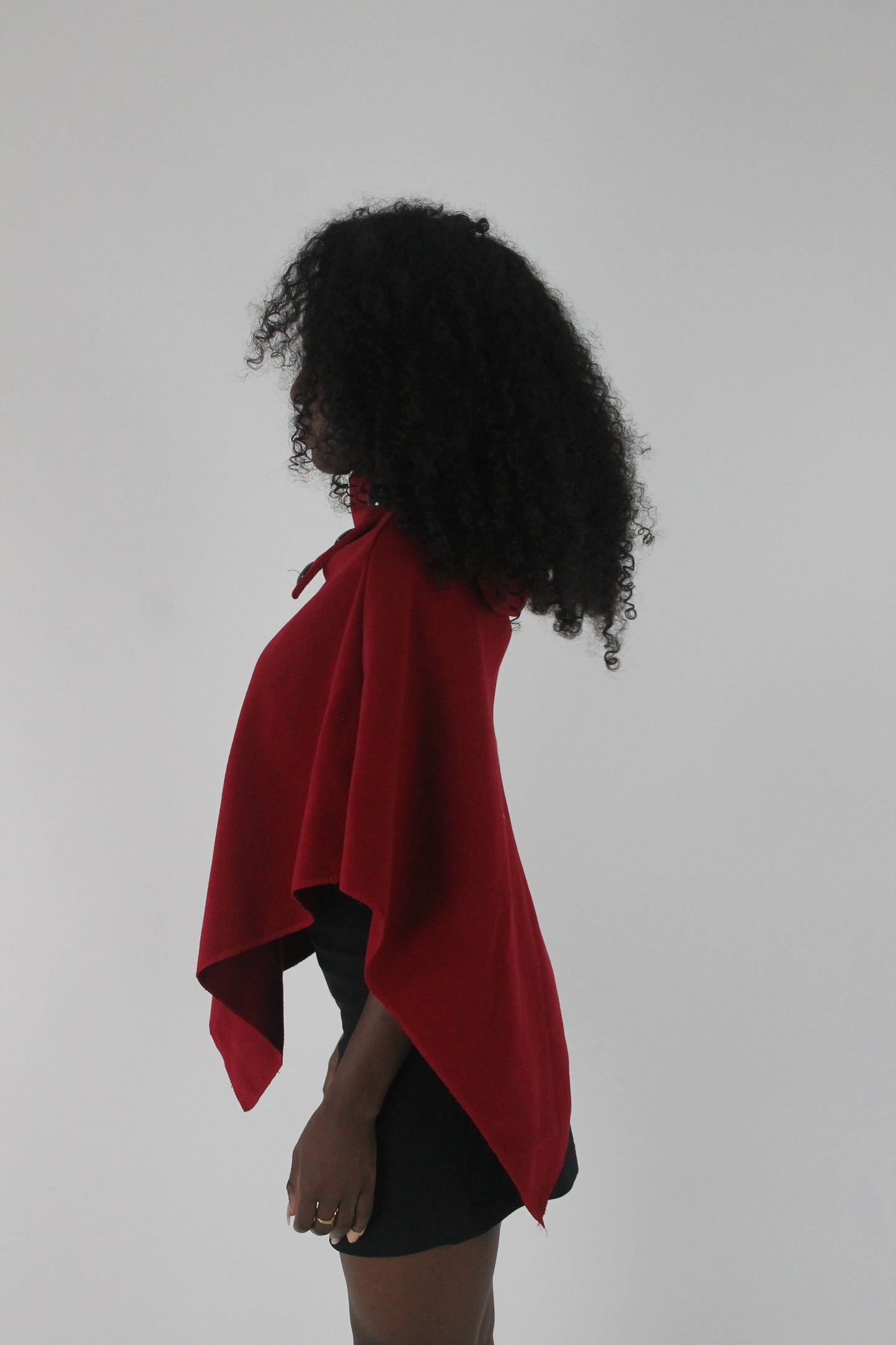side view of red button-detail asymmetric poncho