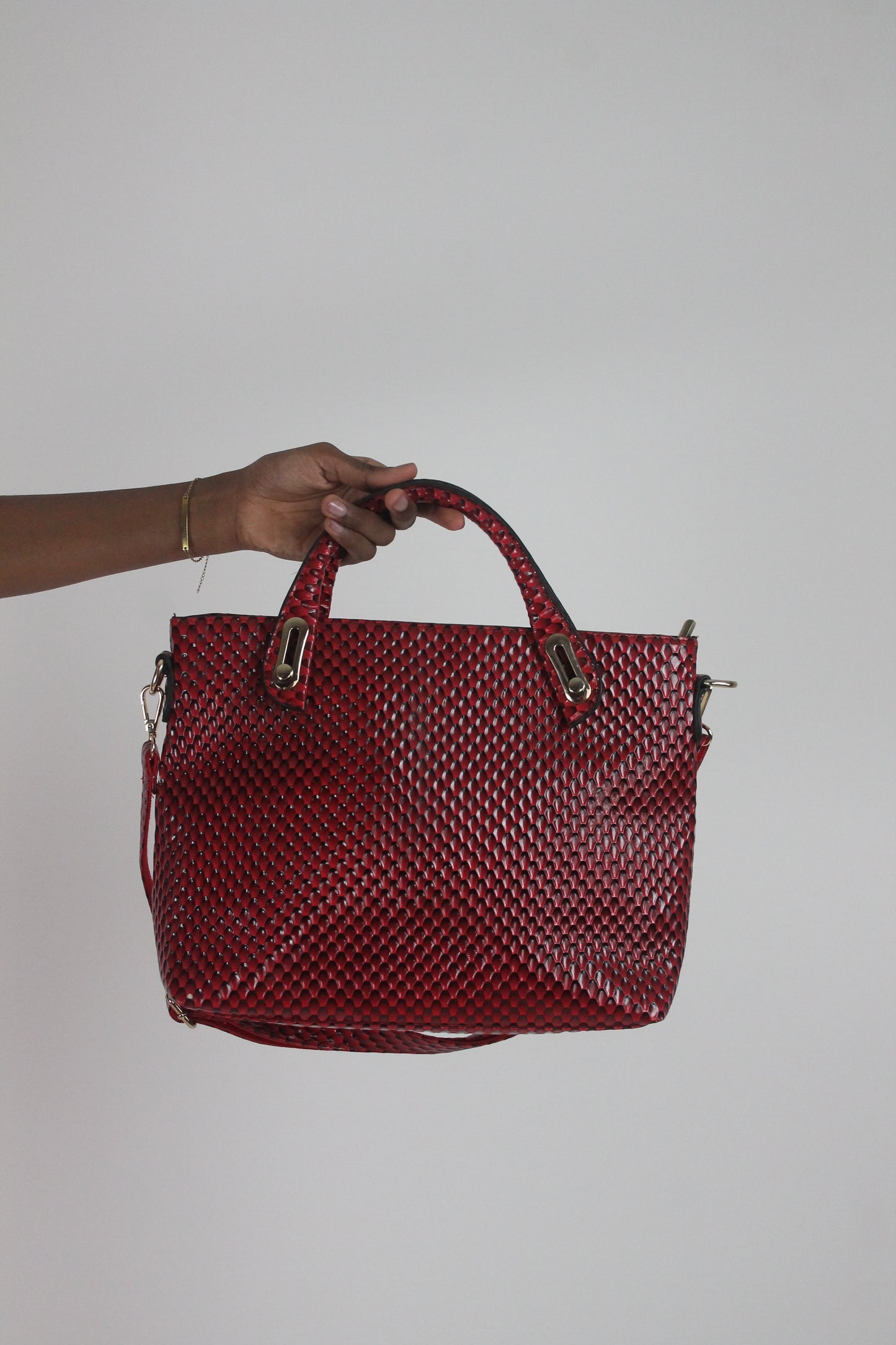back view of red woven-effect structured handbag with shoulder strap