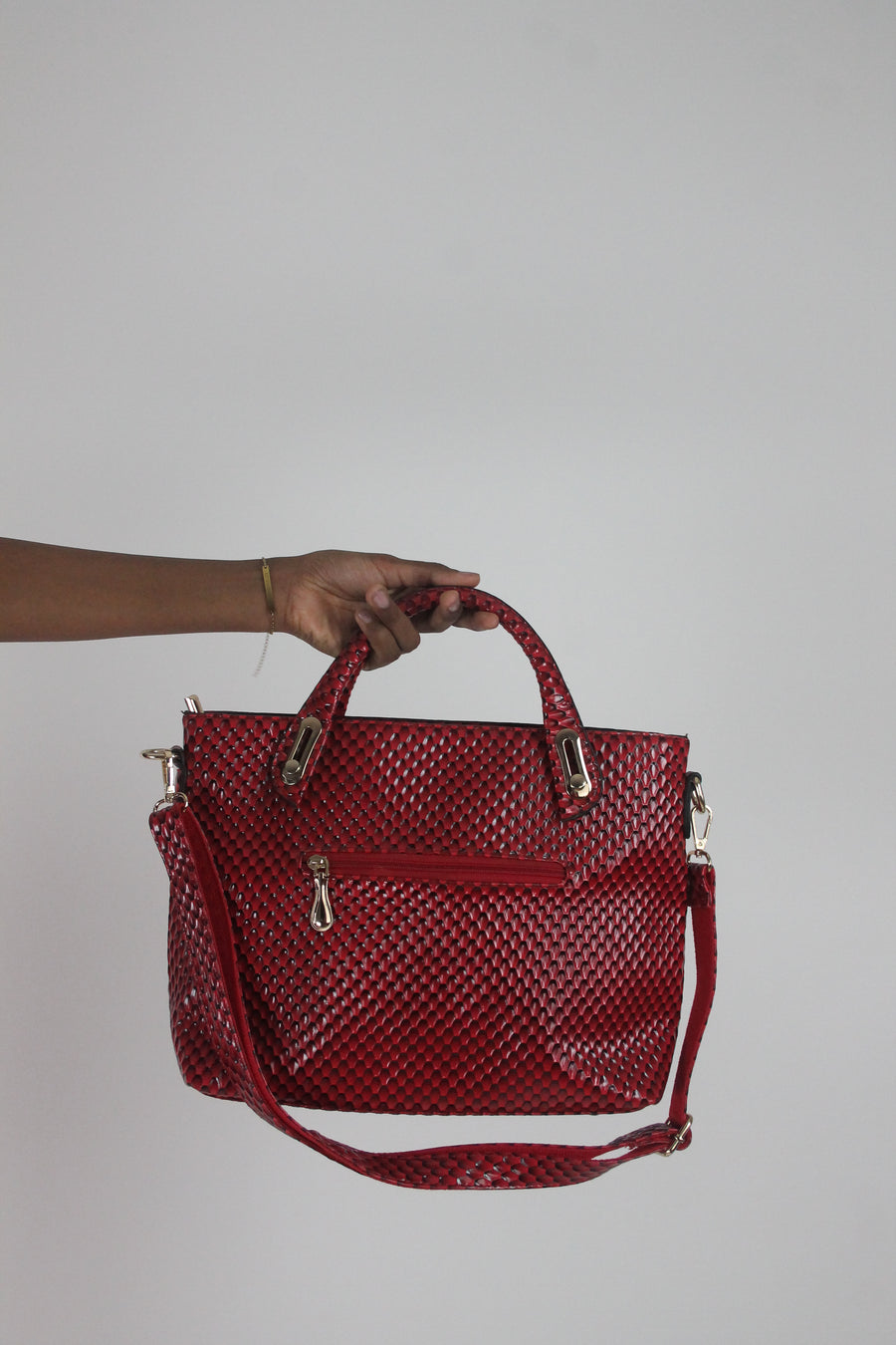 front view of red woven-effect structured handbag with shoulder strap