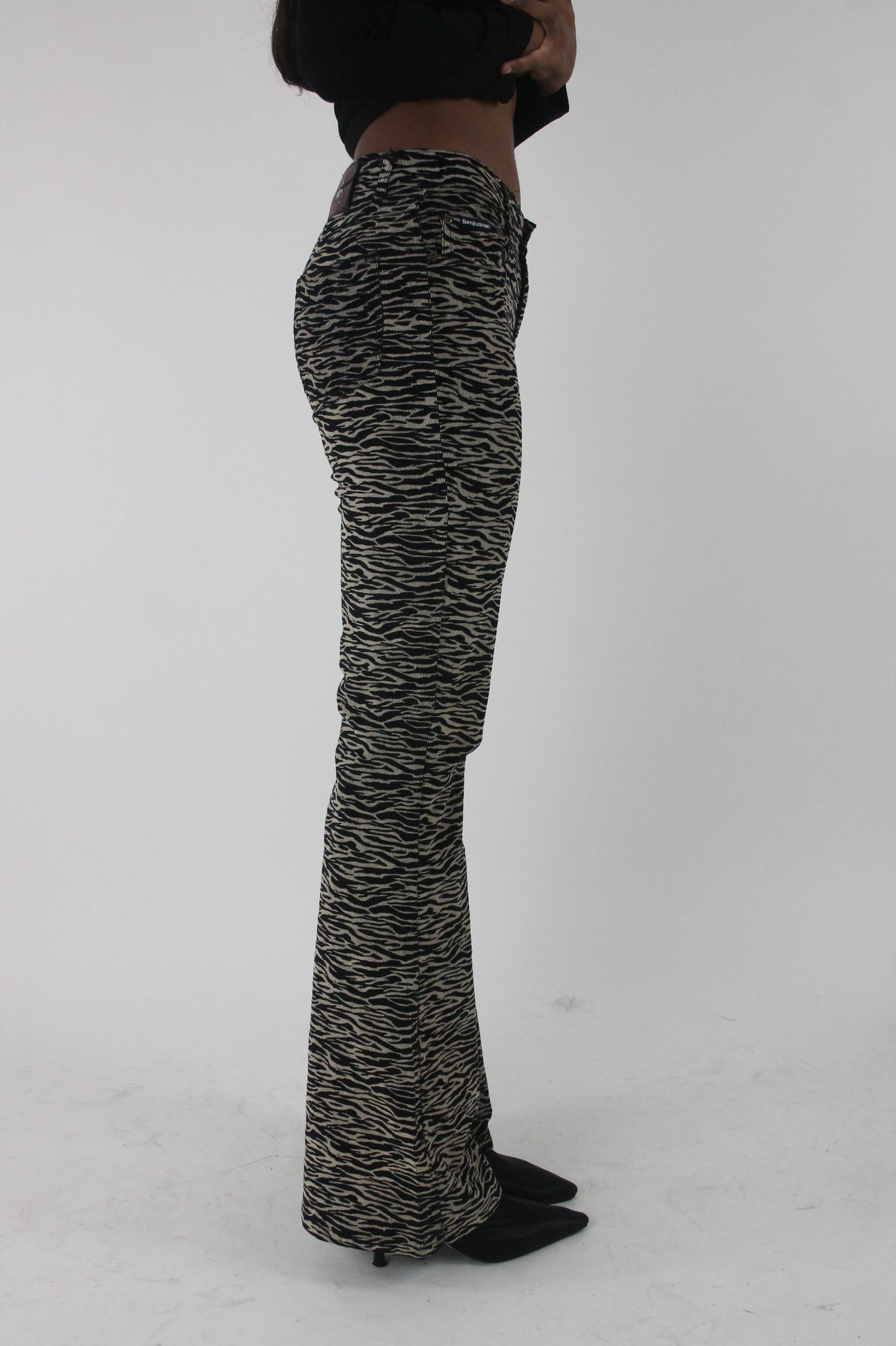 side view of black and cream zebra-print flared trousers