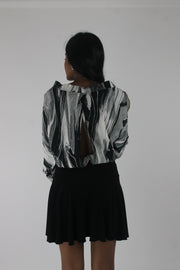 back view of black and grey abstract-striped asymmetric blouse