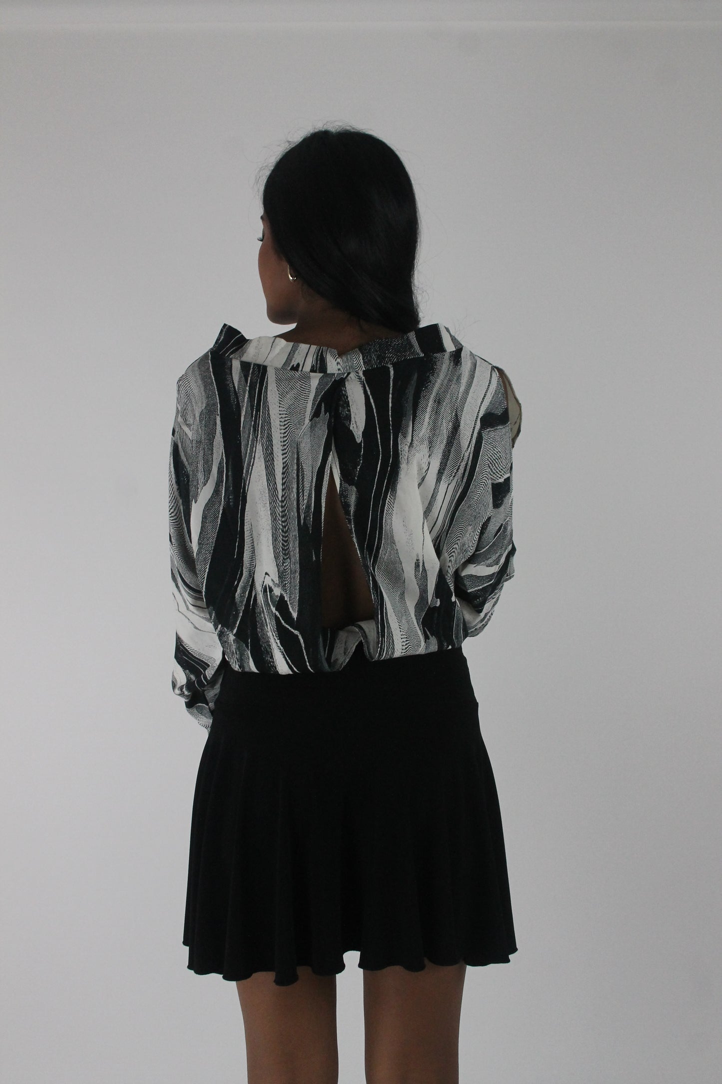 back view of black and grey abstract-striped asymmetric blouse