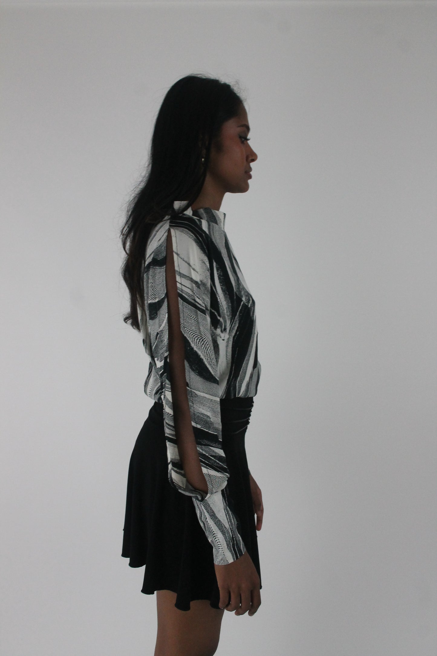 side view of black and grey abstract-striped asymmetric blouse