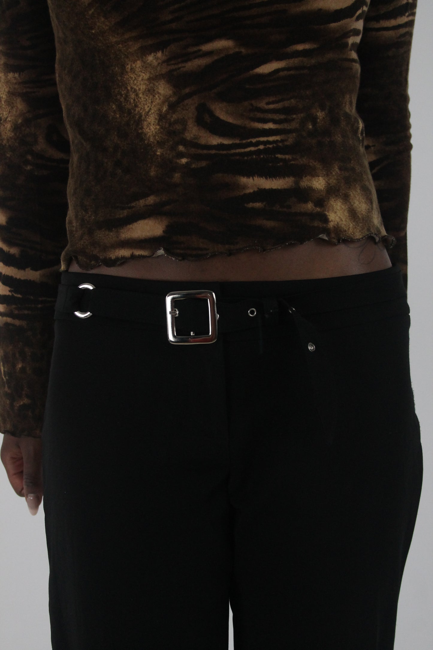 detail view of black buckle-belt flared trousers