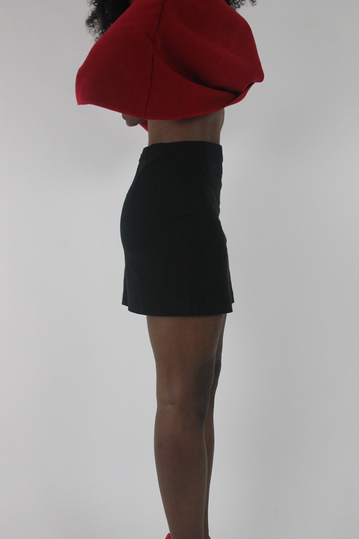 alternate-side view of black fitted tailored mini skirt