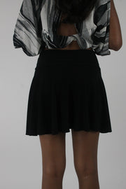 back view of black flared eyelet-waist mini skirt