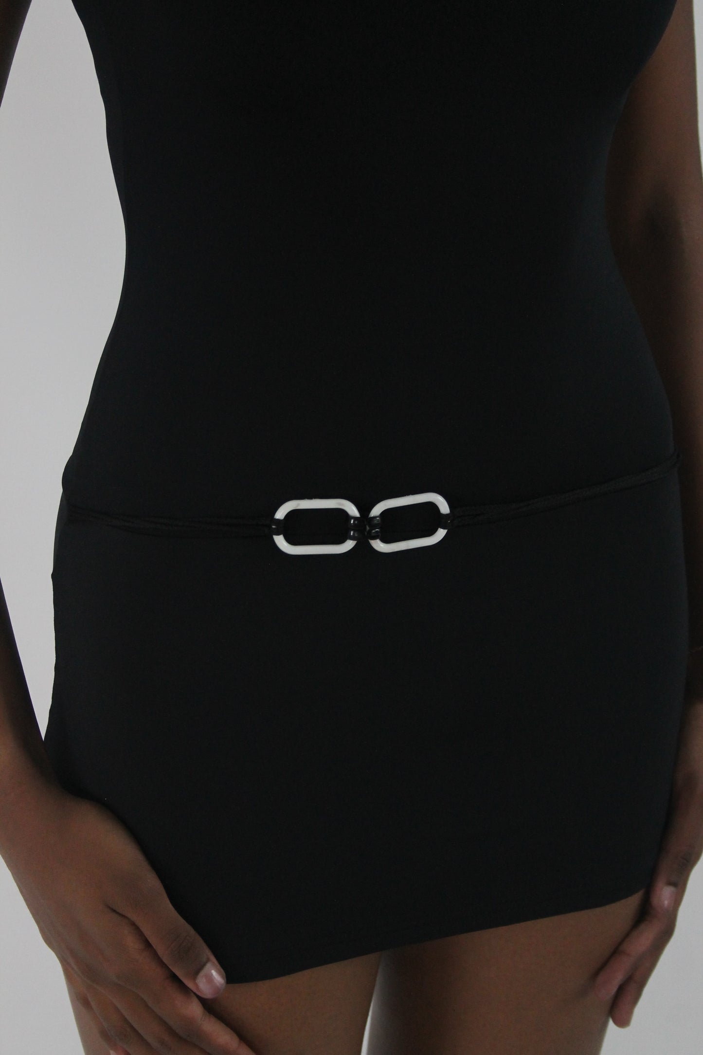 detail view of black high-neck sleeveless buckle-detail mini dress