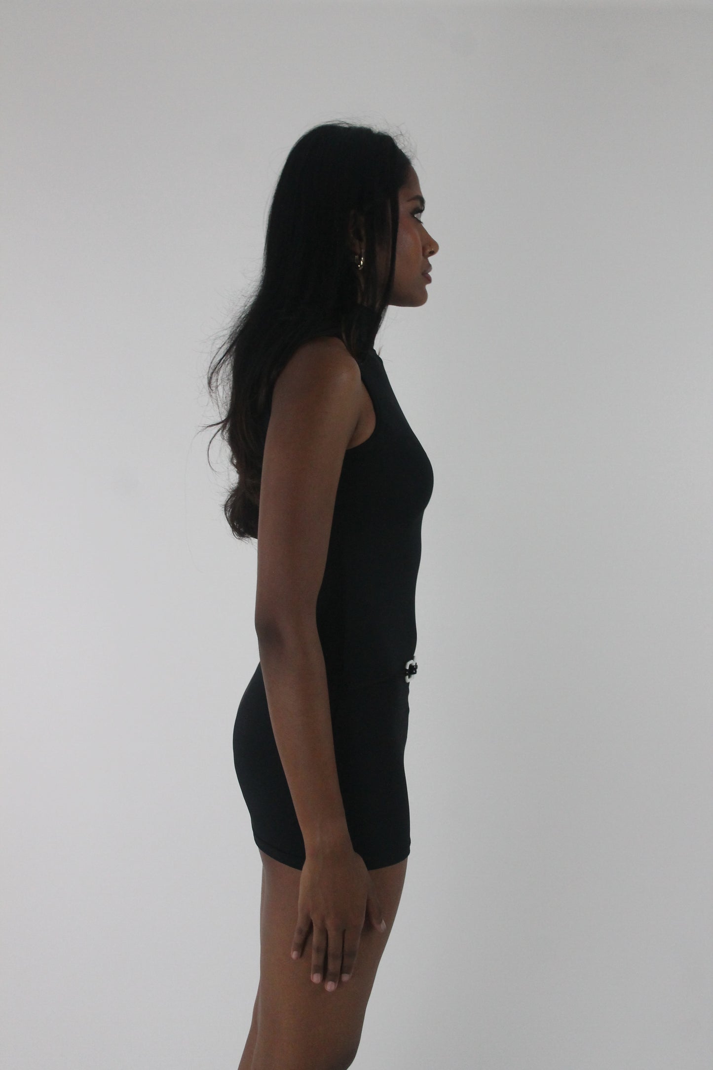 side view of black high-neck sleeveless buckle-detail mini dress