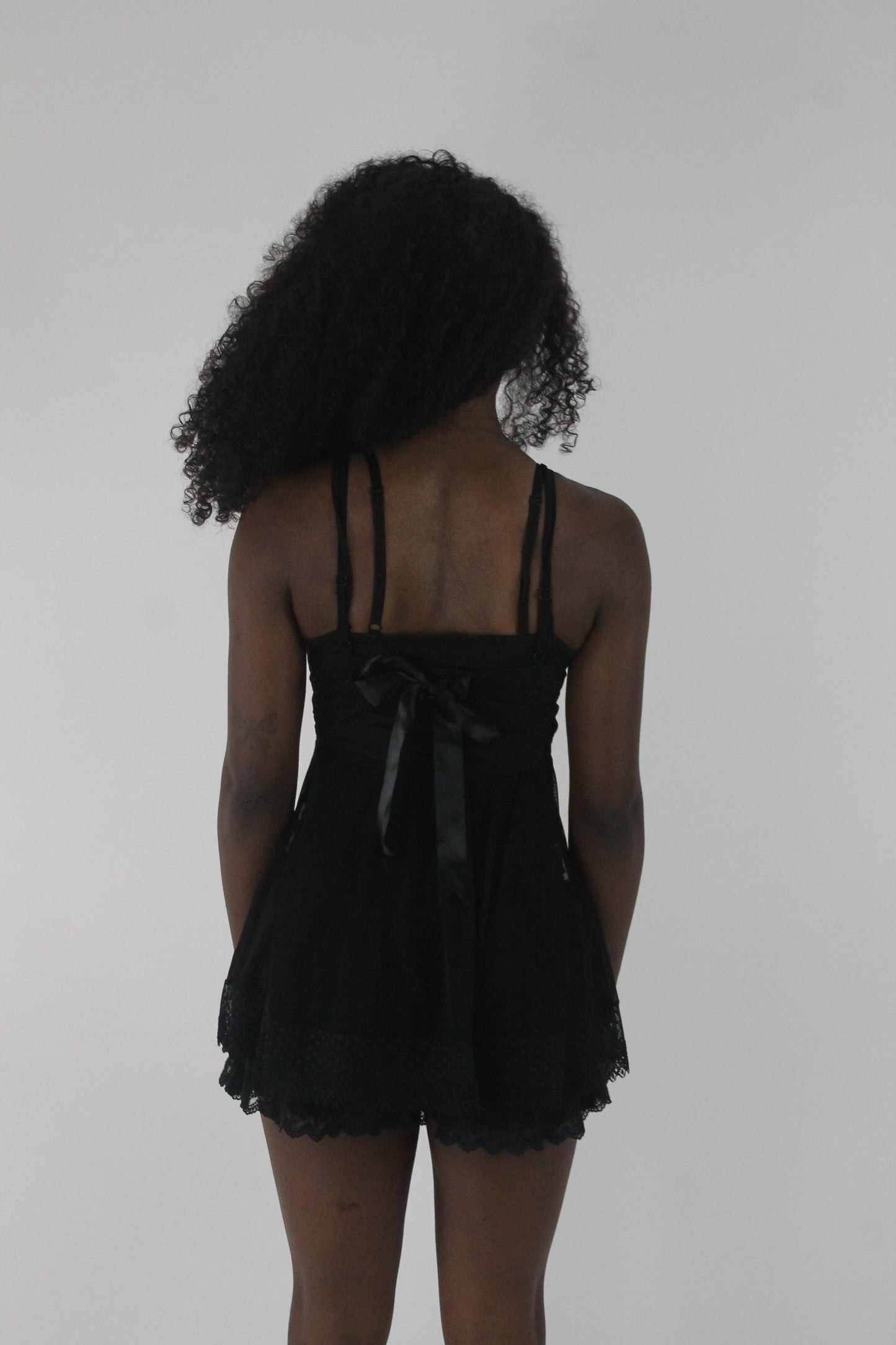 back view of black lace-trim babydoll mini dress