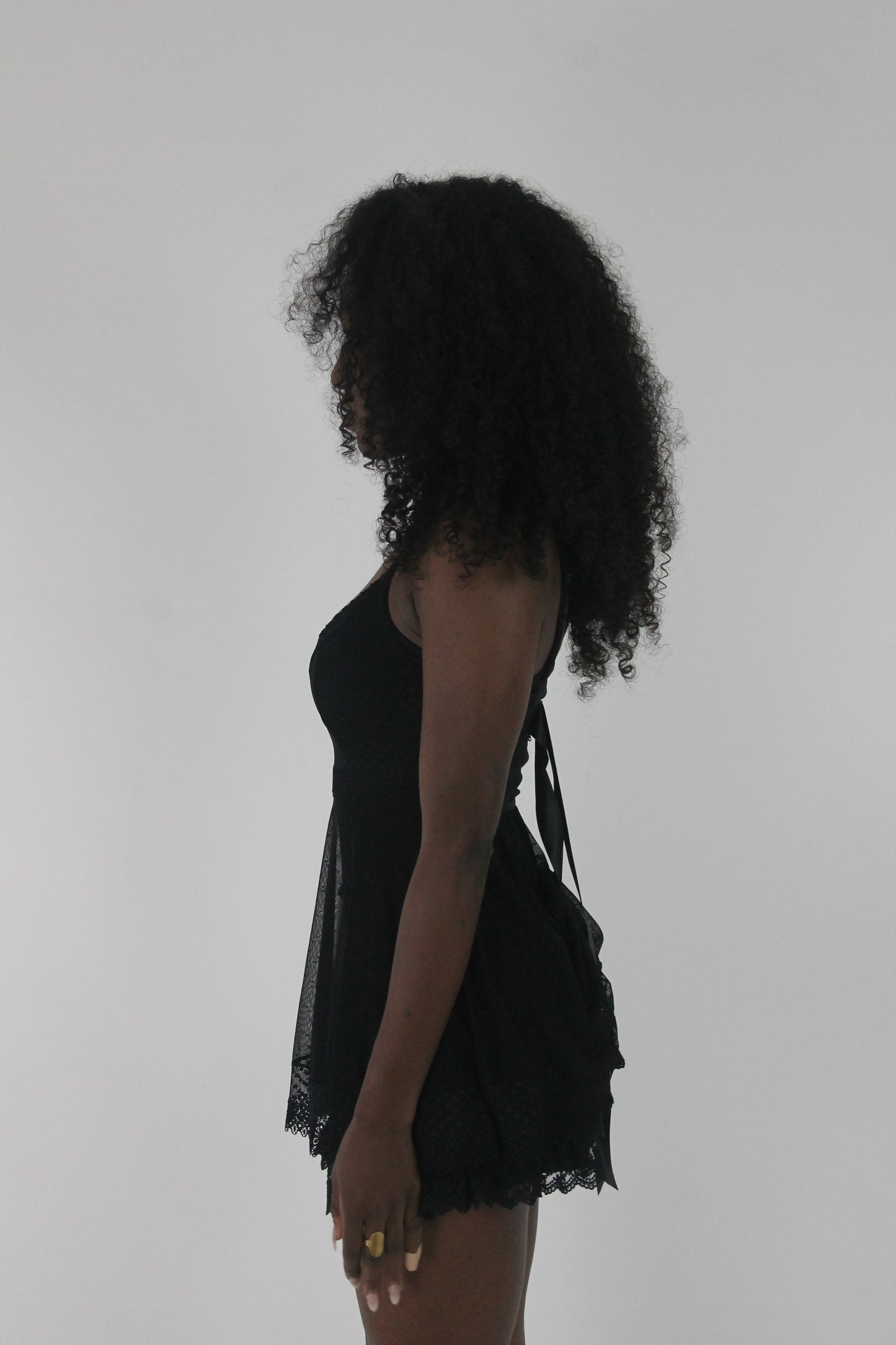 side view of black lace-trim babydoll mini dress