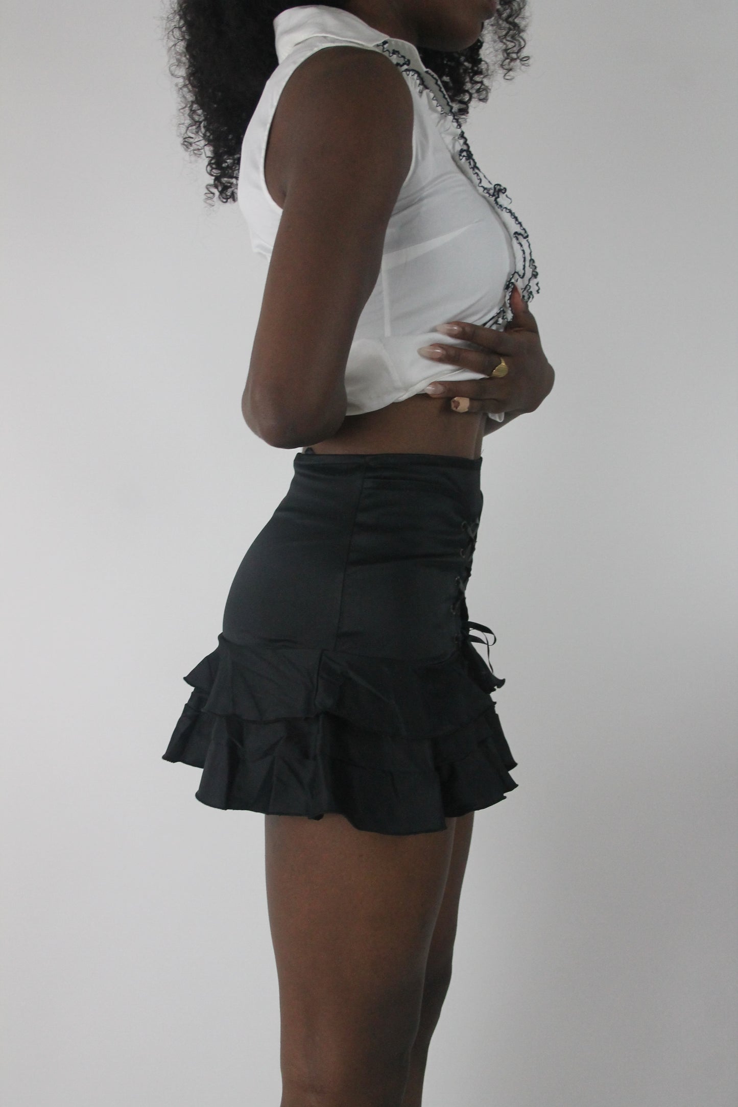 alternate-side view of black lace-up ruffle mini skirt
