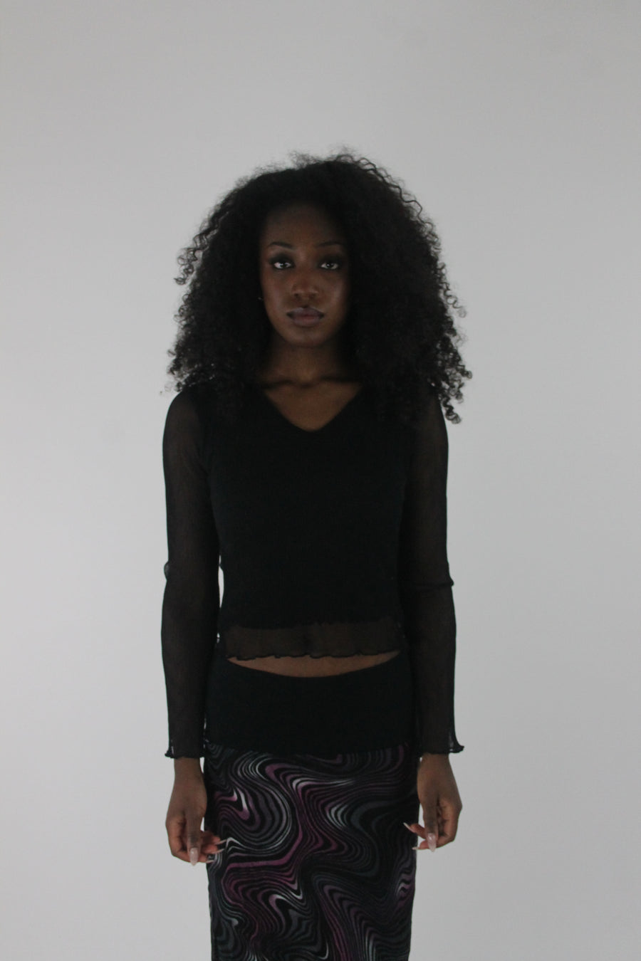 front view of black mesh ruffle-hem long-sleeve top