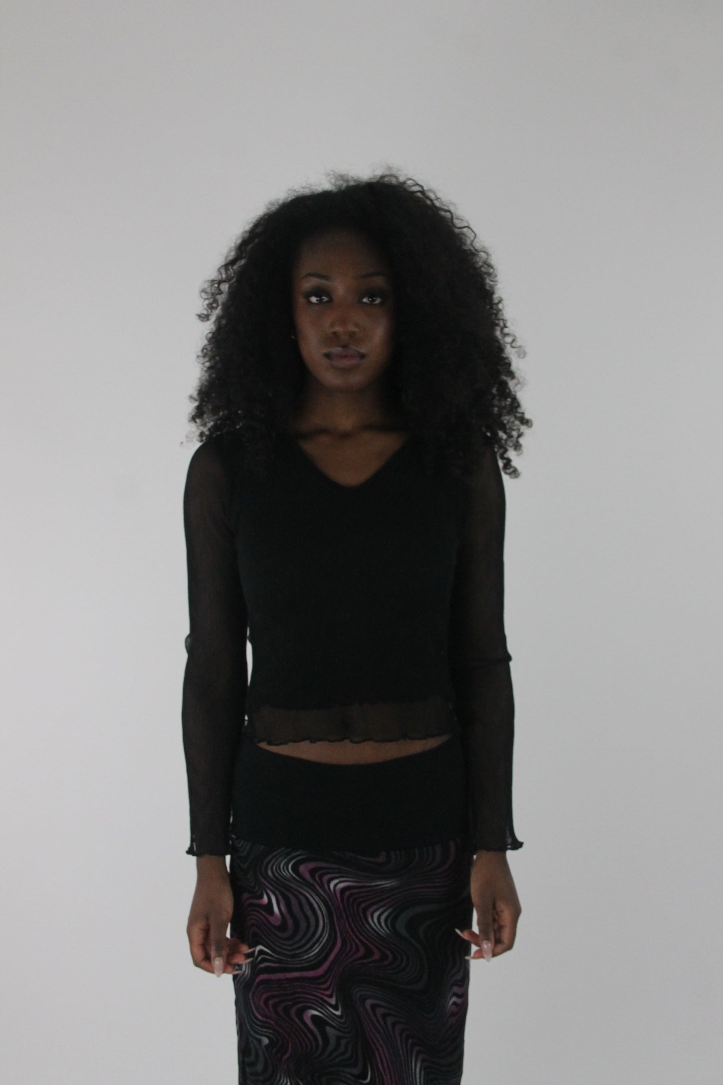 front view of black mesh ruffle-hem long-sleeve top
