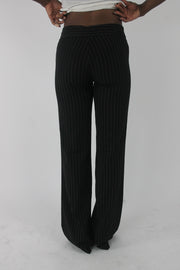 back view of black pinstripe buckle-belt flared trousers