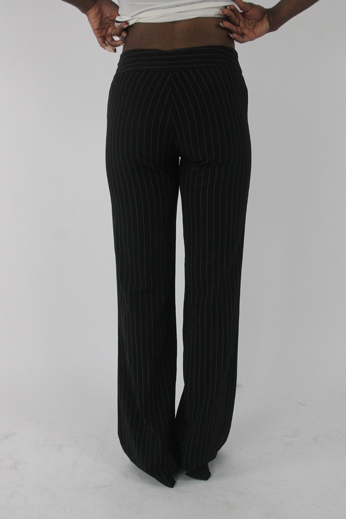 back view of black pinstripe buckle-belt flared trousers