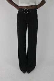 front view of black pinstripe buckle-belt flared trousers