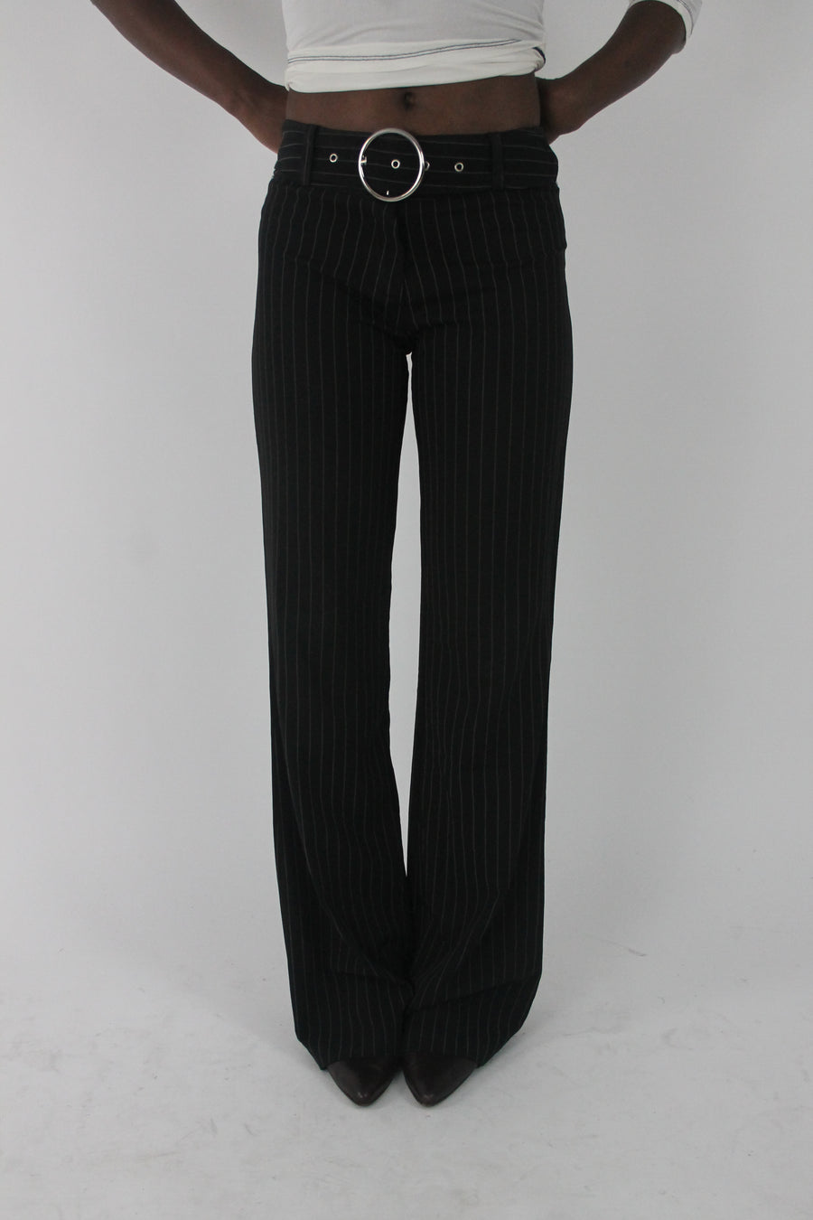 front view of black pinstripe buckle-belt flared trousers