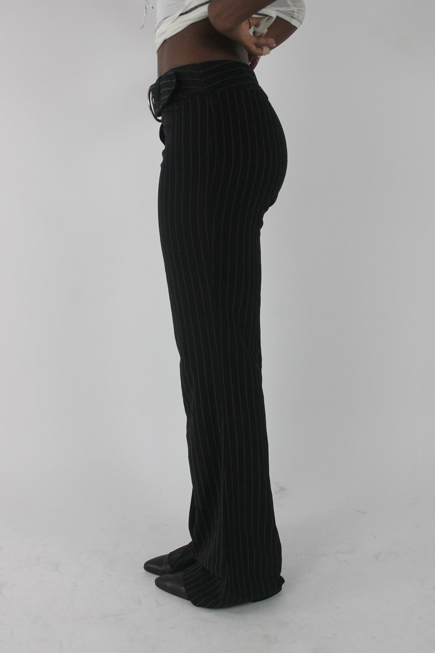 side view of black pinstripe buckle-belt flared trousers