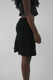 alternate-side view of black pleated mini skirt