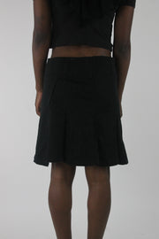 back view of black pleated mini skirt