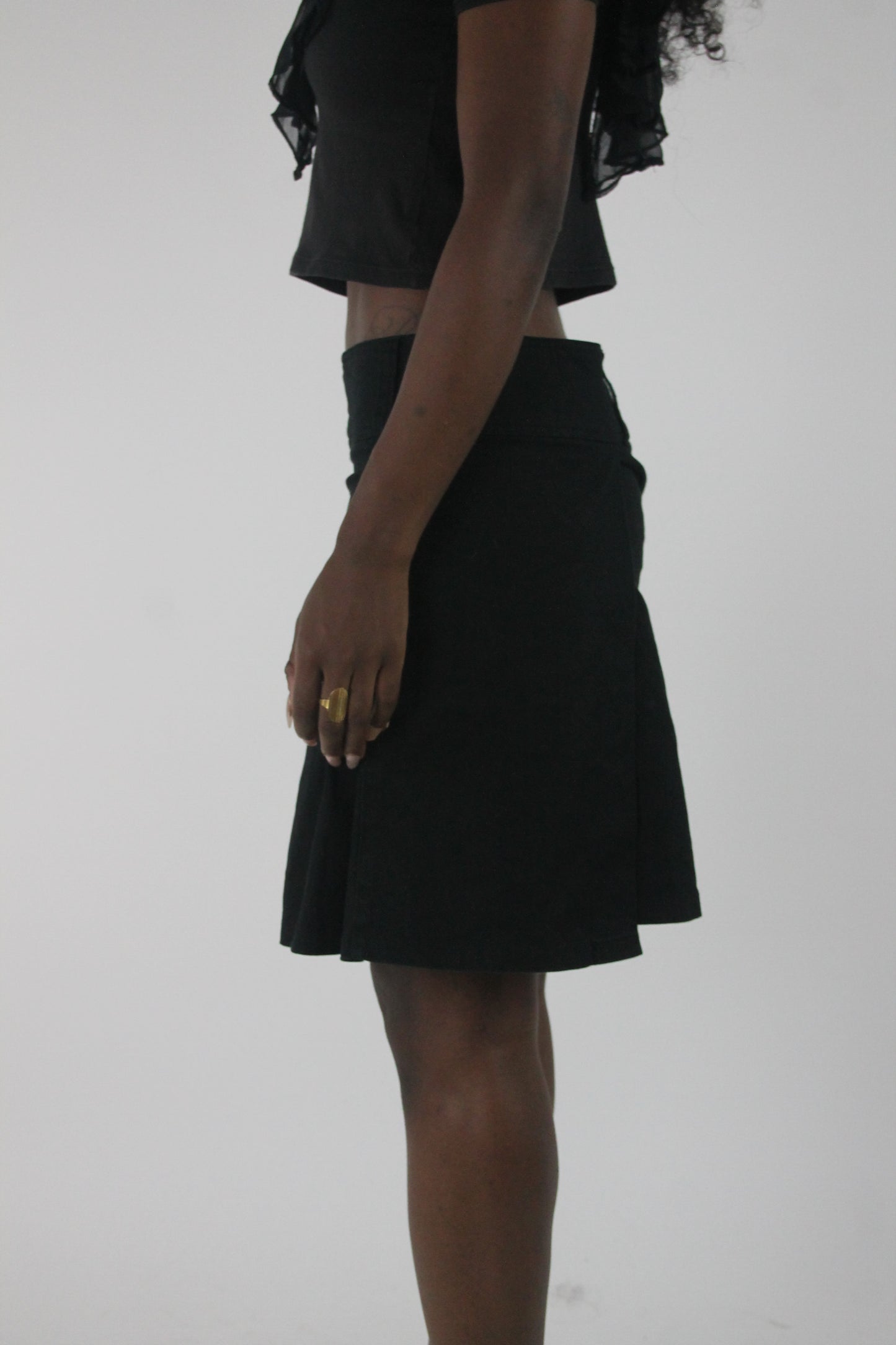 side view of black pleated mini skirt