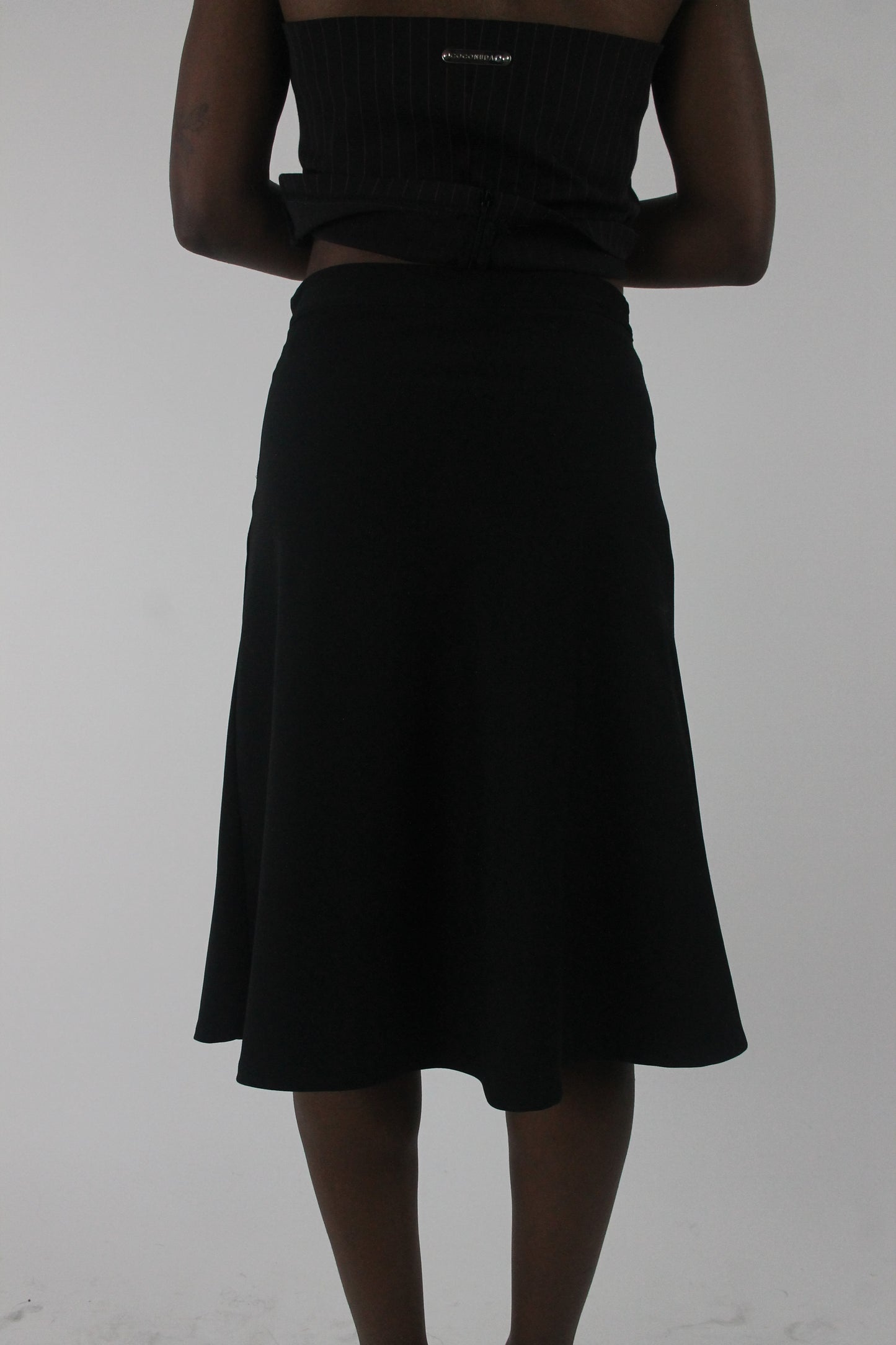 back view of black rhinestone-buckle midi skirt