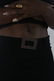 detail view of black rhinestone-buckle midi skirt