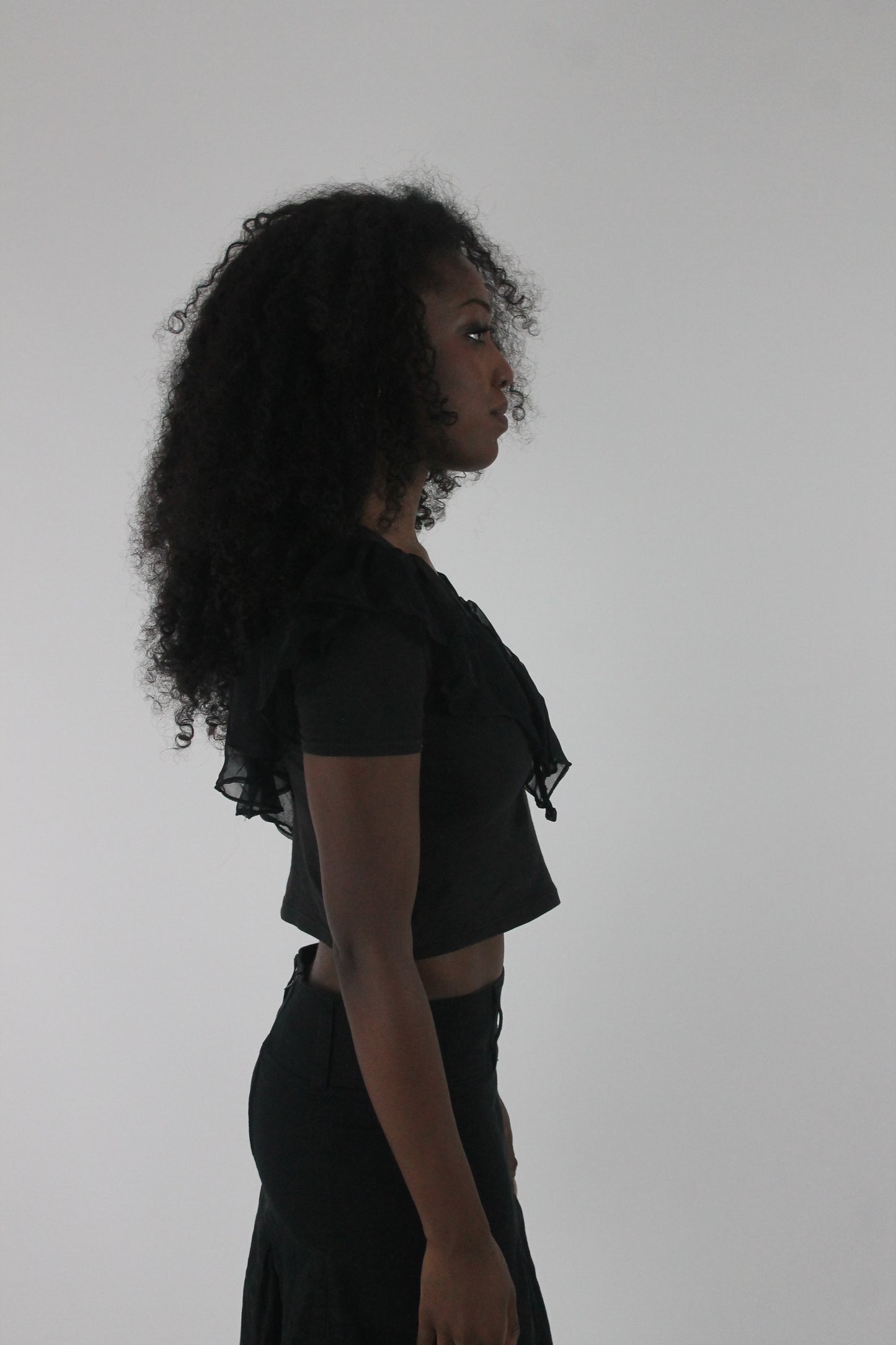 alternate-side view of black ruffle cropped short-sleeve top