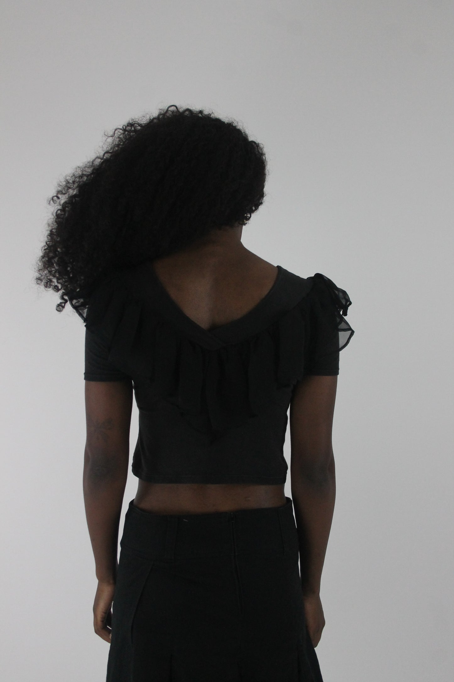 back view of black ruffle cropped short-sleeve top