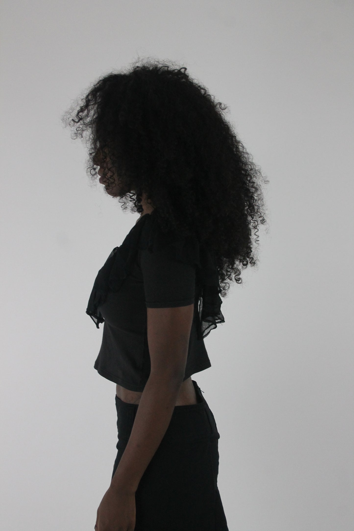 side view of black ruffle cropped short-sleeve top