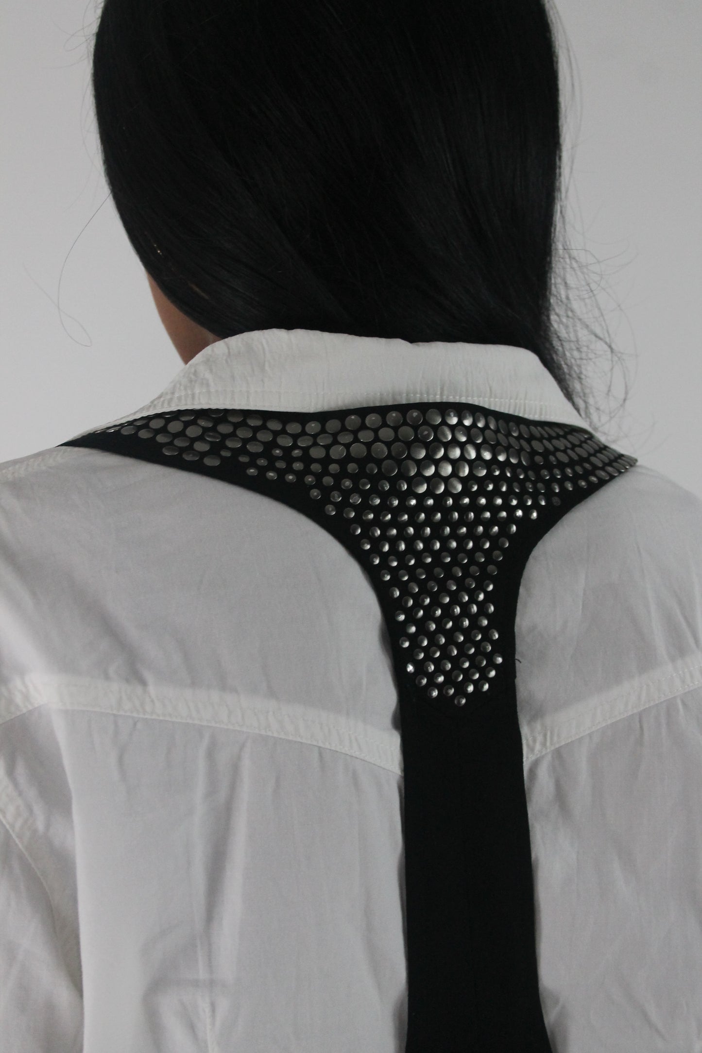 alternate-side view of black studded racerback cropped waistcoat