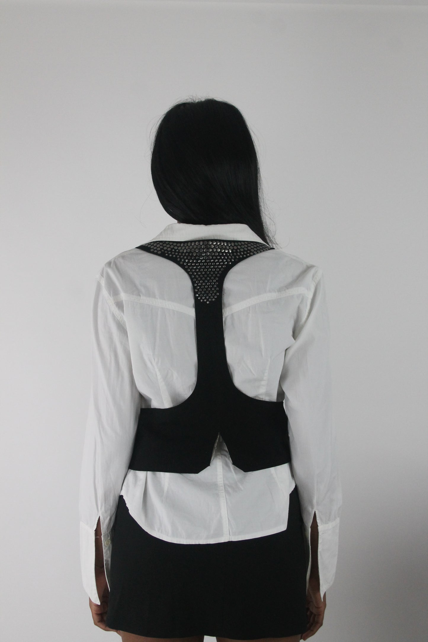 back view of black studded racerback cropped waistcoat