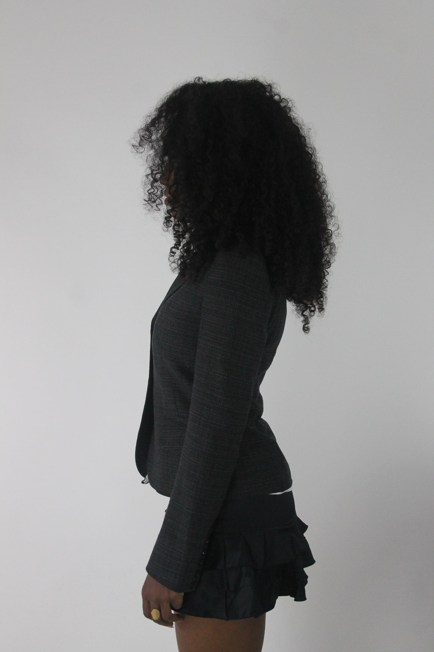 side view of charcoal grey ruffle-hem fitted blazer