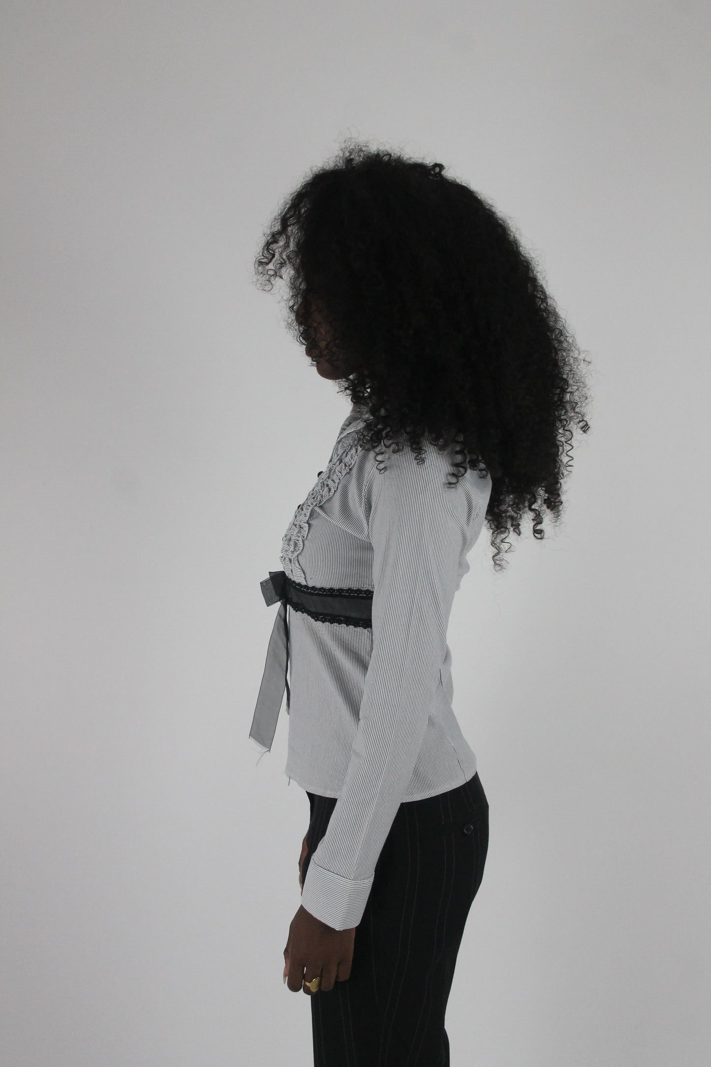 side view of white black-trim tie-front blouse
