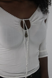 detail view of white cold-shoulder tie-front top
