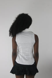back view of white sleeveless collared shirt with black piping